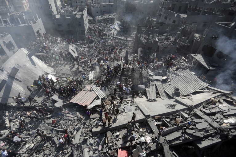 FILE - Palestinians inspect the rubble of destroyed buildings following Israeli airstrikes on town of Khan Younis, southern Gaza Strip on Oct. 26, 2023. (AP Photo/Mohammed Dahman, File)